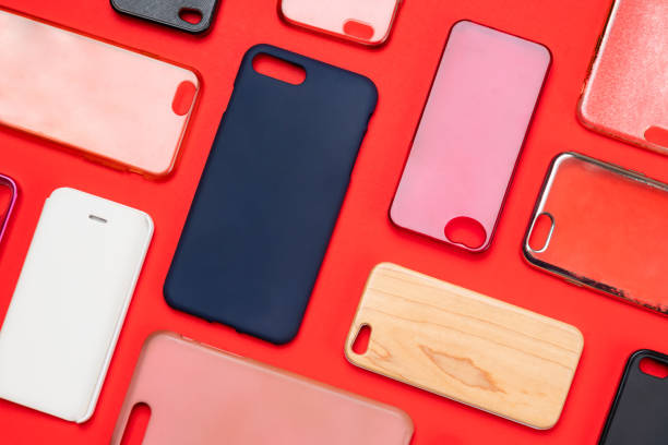 istock Pile of multicolored plastic back covers for mobile phone. Choice of smart phone protector accessories on red background. A lot of silicone phone backs or skins next to each other 1300388811
