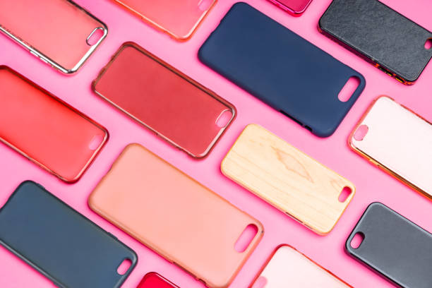 istock Pile of multicolored plastic back covers for mobile phone. Choice of smart phone protector accessories on pink background. A lot of silicone phone backs or skins next to each other 1300388822