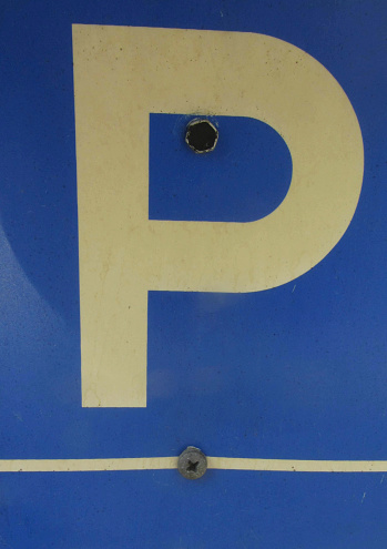 a blue parking lot road sign with a white P letter