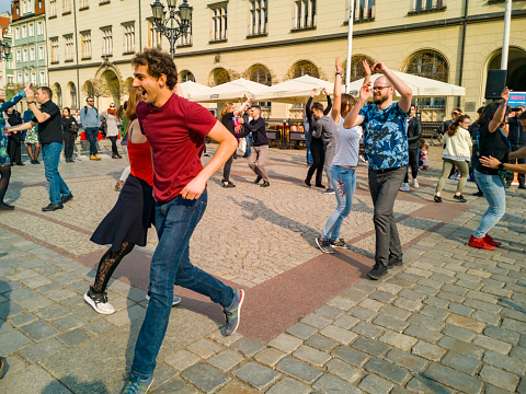 Group of happy tourists communicating while walking through the city streets.