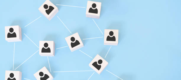 istock Organization structure, team building, business management or human resources concepts. Person icons on wooden cubes linked to each other. 1300392204