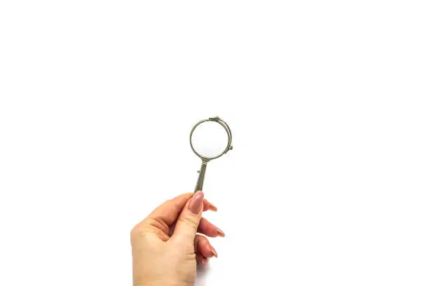 Photo of Hand hold an old vintage lorgnette from the middle of the nineteenth century on the white background