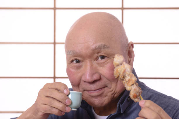 焼き鳥を食べて日本酒を飲む - spit roasted 日本食 焼き鳥 japanese culture ストックフォトと画像