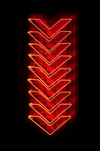 Set of red arrows neon light pointing down.