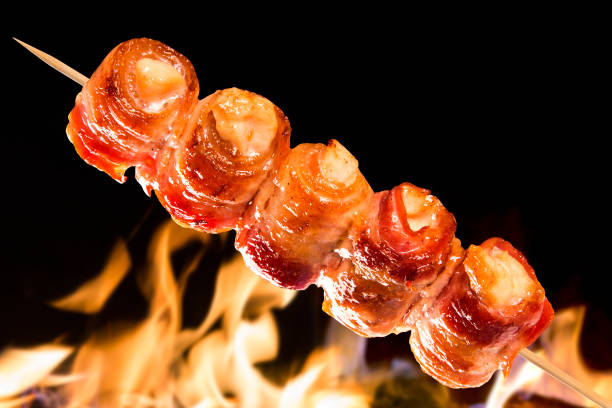 Chicken skewer with bacon on a fire background