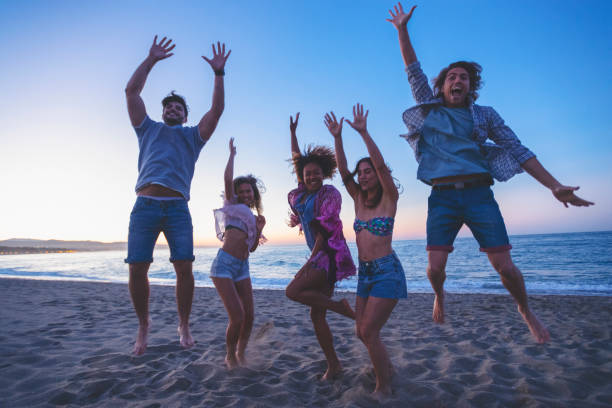 istock Group of friends jumping for joy on the beach. 1300395904