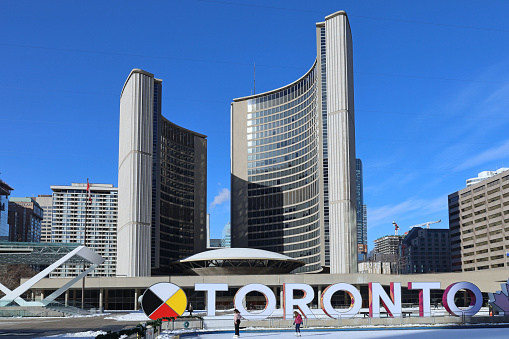 Toronto, Canada - February 4, 2021:  Toronto's City Hall has a skating rink in the public square in winter.