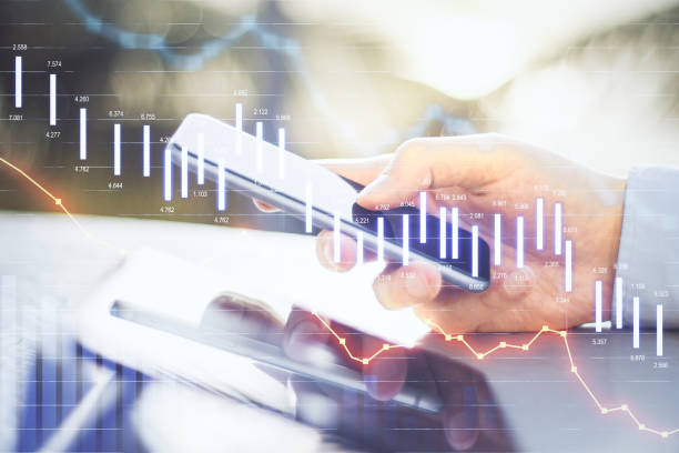 istock Digital screen of forex chart with going down graphs and man using cell phone 1300398177