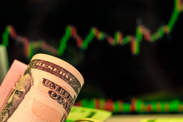 istock American dollar banknotes and graph on black background 1300402912