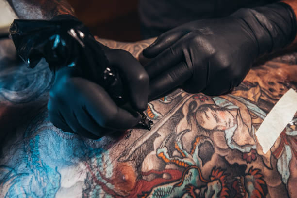 Tattoos are what feelings look like Shot of a tattoo artist at work forearm tattoos men stock pictures, royalty-free photos & images