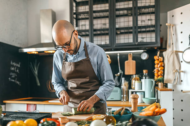 istock Young man chopping zucchini on a cutting board 1300405035