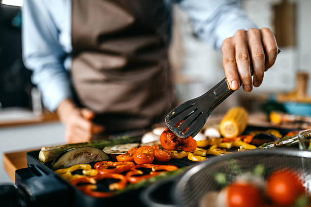 istock Young man grilling vegetables on electric barbecue grill 1300405086