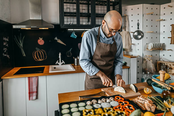 istock Young man chopping eggplant on a cutting board 1300406059