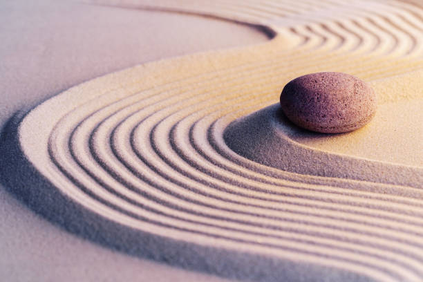 istock Meditation zen garden with stones on sand 1300407793