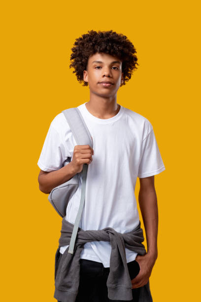 smart black student casual lifestyle teenager Smart black student. Casual lifestyle. Confident african teenager with backpack looking at camera isolated on orange. Knowledge and skills. Educational courses teenage boys stock pictures, royalty-free photos & images