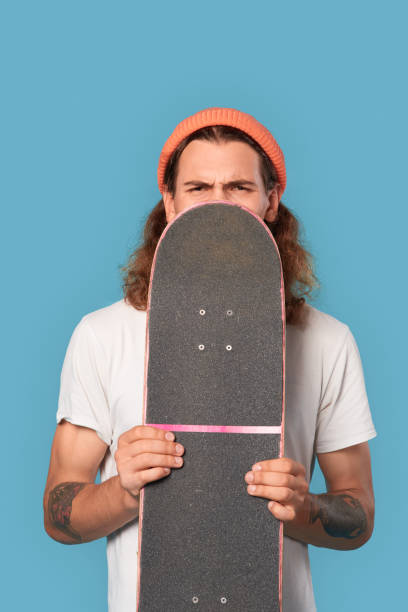 istock Young adult guy covered face with skateboard 1300410901