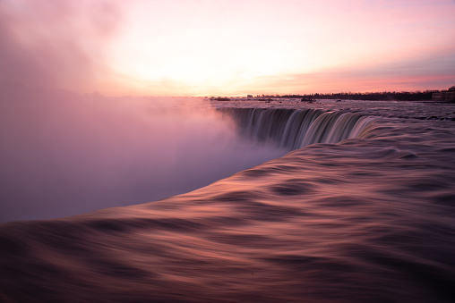 The sunrise over Niagara Falls showing the unique colours in the sky with the reflection on the smooth water