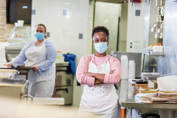 afroamerikanische frau in cafeteria küche, mit maske - kantinenfrau stock-fotos und bilder