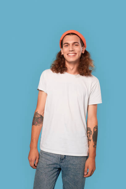 istock Young adult man looking at camera and smiling wide 1300421425