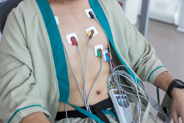 herzelektrokardiogramm oder überwachung mit holter für junge patienten. männliche sportler macht einen herz-stress-test. holter monitorgerät zur täglichen überwachung eines elektrokardiogramms. - pulse trace arrhythmia electrode listening to heartbeat stock-fotos und bilder