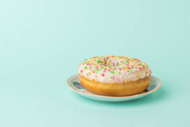 istock Beautiful glazed donut in a plate on a blue background. 1300423230