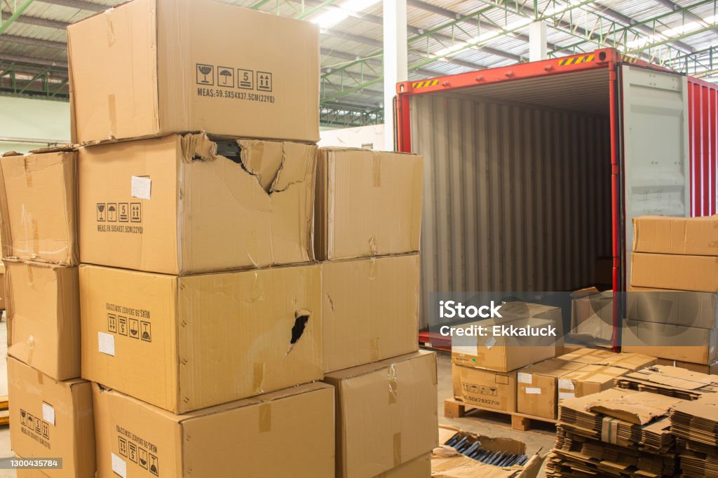 unloading carton from container and carton damage from loading or transport process. Freight Transportation Stock Photo