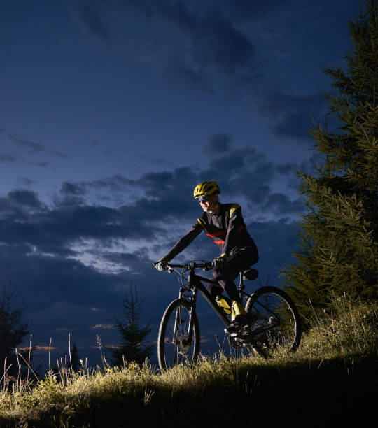 istock Cheerful male cyclist riding bicycle at night. 1300436020