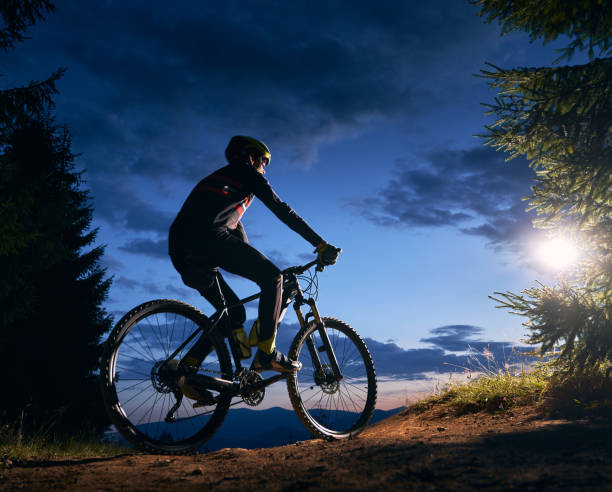 istock Male cyclist sitting on bicycle under beautiful night sky. 1300436042