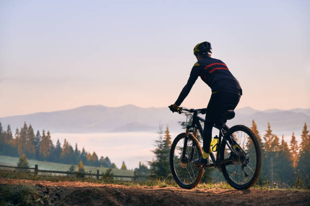 istock Smiling young man riding bicycle on mountain road. 1300436068