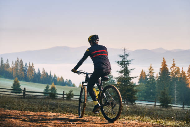 istock Smiling young man riding bicycle on mountain road. 1300436070