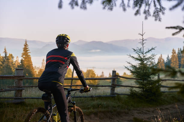 istock Smiling young man riding bicycle on mountain road. 1300438572