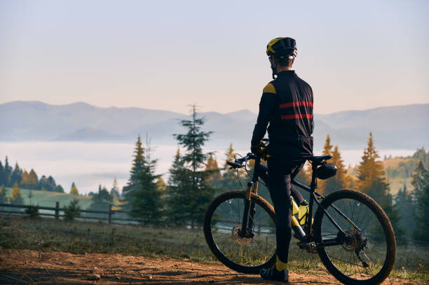 istock Smiling young man riding bicycle on mountain road. 1300438574