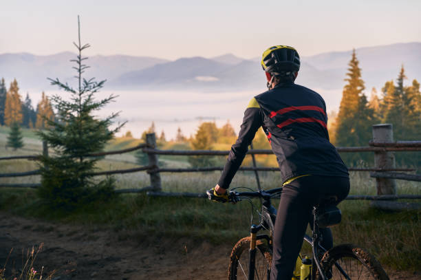 istock Smiling young man riding bicycle on mountain road. 1300438577
