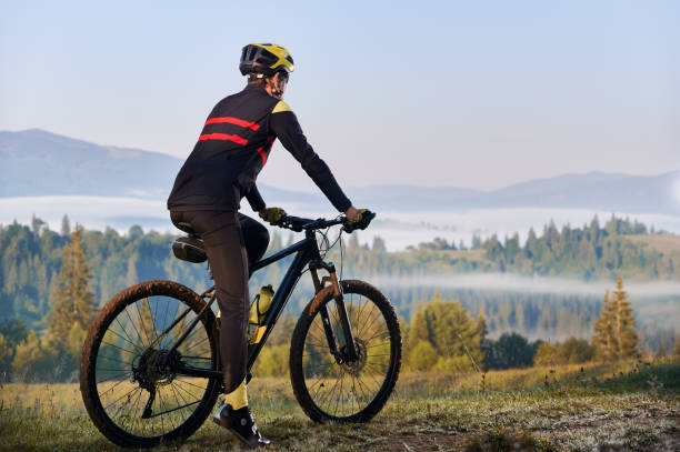 istock Smiling young man riding bicycle on mountain road. 1300438587