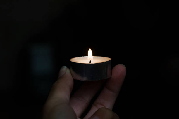 istock Candle in a hand closeup in the dark 1300440947