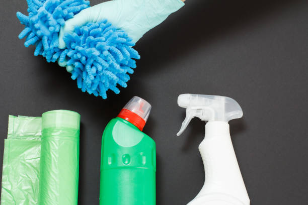istock Hand in a glove with a rag and cleaning set on the black background. 1300441887