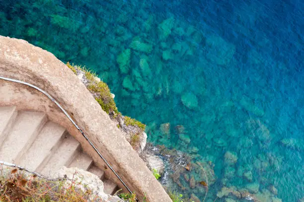 Old stone stairway goes down to the sea on rocky coast. Bonifacio, Corsica