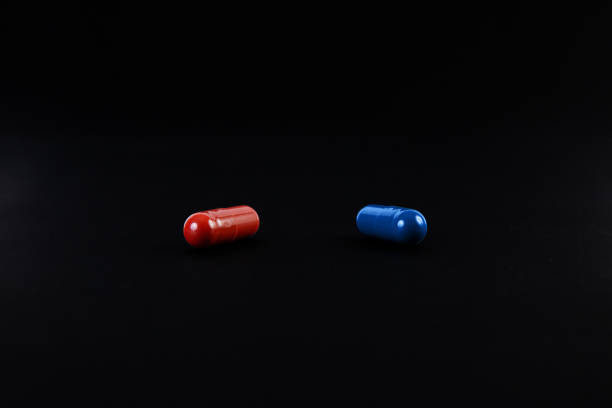 Red Pill And A Blue Pill On Black Background. The Concept Of Choice.