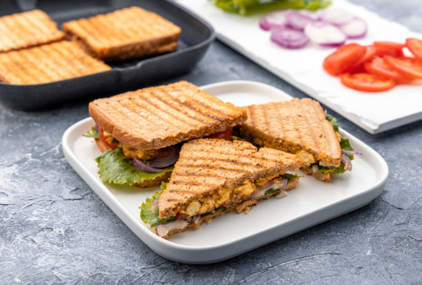 vegetable paneer sandwich using cottage cheese  with tomato, onion and lettuce with chutney vegetable sandwiches are being made with cottage cheese, onions, tomato and lettuce appetizer plate stock pictures, royalty-free photos & images