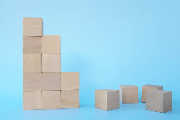 istock Broken or fallen building blocks in blue background. Crisis, recession and economy collapse concept. 1300445124