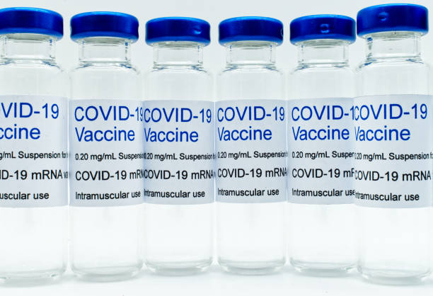 istock Transparent empty glass vials with Covid-19 Vaccine labels. Close-up 1300445220