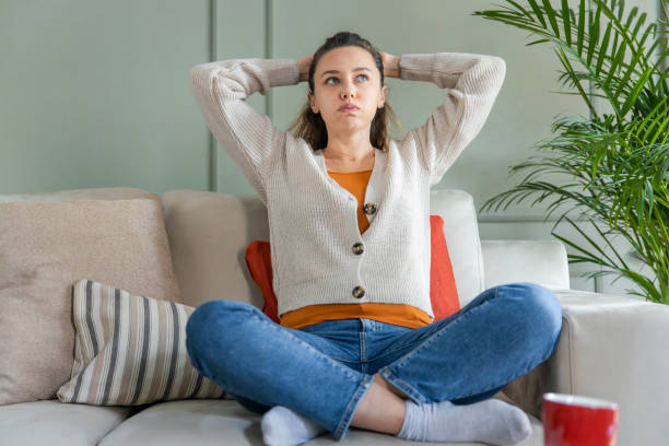 istock Depressed young woman on sofa at home 1300446292