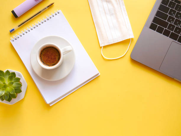 flat lay composition with laptop, notebook, mask, pen, coffee, plant on yellow background. Concept remote study and work at home, telework, freelance, quarantine. Coffee break, office table. Copyspace flat lay composition with notebook, mask, pen, coffee, plant on yellow background. Concept remote study and work at home, telework, freelance, quarantine. Coffee break, office table. Copyspace. office cubicle mask stock pictures, royalty-free photos & images