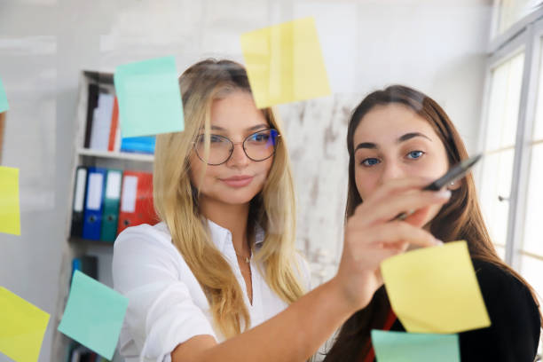 istock Two businesswomen looking at sticky notes 1300449874