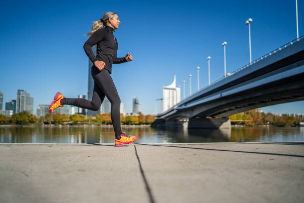 deportista corriendo a lo largo del río en la ciudad - bridge confidence inspiration motivation fotografías e imágenes de stock