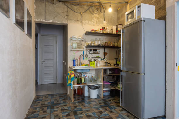 o interior da sala de estar combinado com uma cozinha sem reforma com um conjunto de cozinha temporário - poverty ugliness residential structure usa - fotografias e filmes do acervo