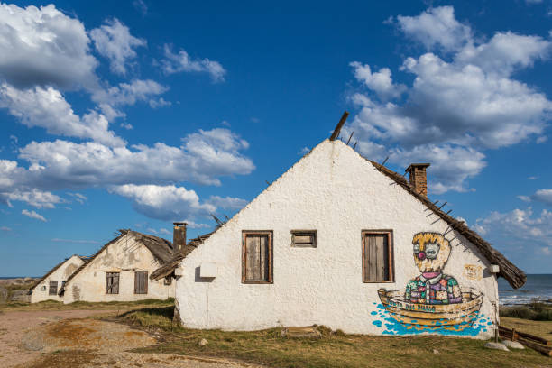 Small white house with painting of a boat on the side