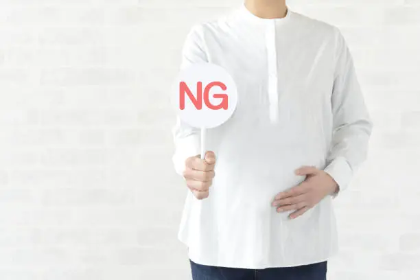 Photo of Pregnant woman having plate with NG word