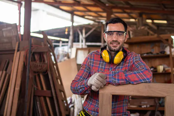 Photo of carpenter is working in a woodworking office.Worker Portrait caucasion white Carpenter standing and looking at camera