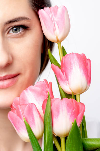 istock Young woman with pink tulips 1300454827